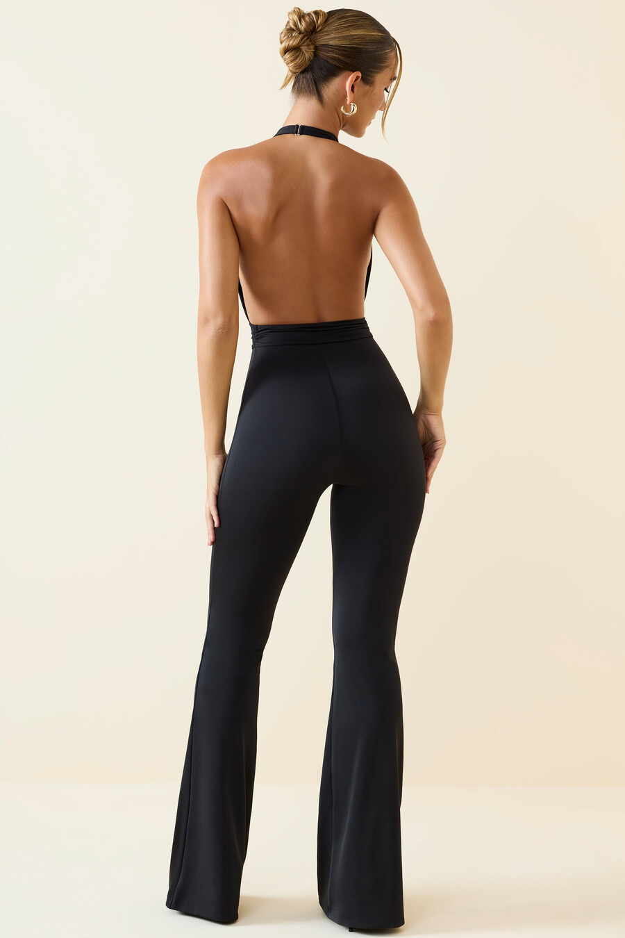 jumpsuit met halternek uitlopende pijpen en uitsparingen in zwart.